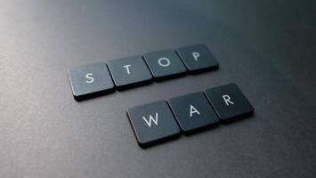 Stop war word made from black plastic buttons on grey background, stop war concept photo