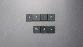 Stop war word made from black plastic buttons on grey background, stop war concept photo