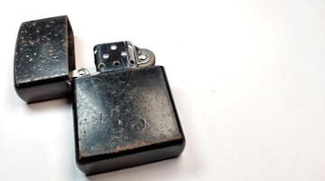 Old metal lighter on a white background. Close up. Selective focus. photo