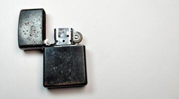 Old metal lighter on a white background. Close up. Selective focus. photo