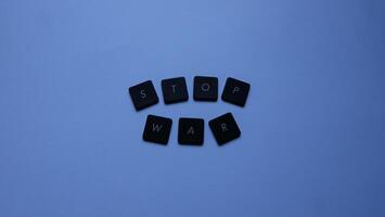 Stop war word made from black plastic buttons on grey background, stop war concept photo