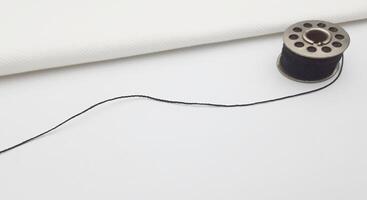 Sewing thread on a white sheet of paper with copy space photo