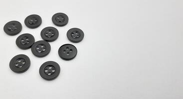 Black sewing buttons isolated on white background. Copy space for text. photo