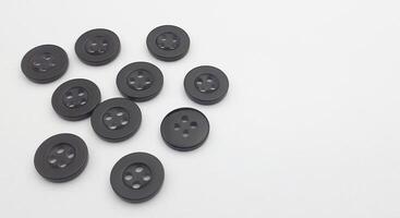 Black sewing buttons isolated on white background. Copy space for text. photo