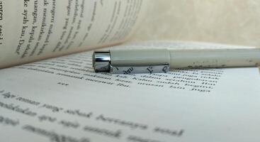 Close-up of a fountain pen on an open book, selective focus photo