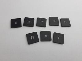 The word earth day spelled out with black buttons on a white background photo