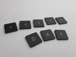 The word earth day spelled out with black buttons on a white background photo
