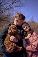 wife, husband and their cockapoo cuddle in the spring sun photo