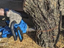 man in protective gloves cleaning wooden wheel with a vacuum cleaner photo