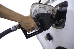 Hand pumps gasoline into car photo
