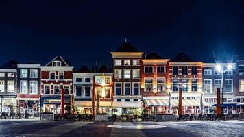 Nighttime View of Historic Row Houses and Cafes in Market Square, Delft, Netherlands photo