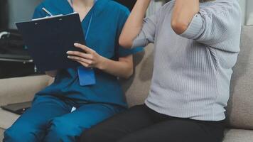 fechar acima doutor, ásia médico conversa com velho fêmea paciente sobre doença sintoma, médico usar estetoscópio ouvindo pulmão do paciente, idosos saúde Verifica acima, felicidade hospital video