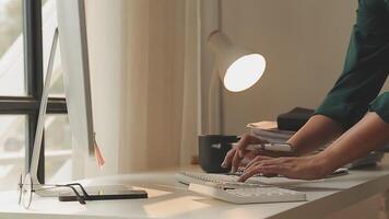 Hands of young contemporary office manager over laptop keypad during work over new business project by table video