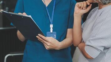 proche en haut médecin, asiatique médecin parler avec vieux femelle patient à propos maladie symptôme, médecin utilisation stéthoscope écoute poumon de patient, personnes âgées santé vérifier en haut, bonheur hôpital video