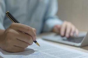 Male hands writing a contract on work paper or signing a business document. Filling out employee forms to apply for jobs or writing agreements and questionnaires photo