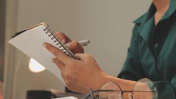 el retrato de una joven mujer asiática independiente está trabajando en su trabajo en una tableta de computadora en una oficina moderna. hacer un informe de análisis contable datos de inversión inmobiliaria, concepto de sistemas financieros y fiscales. video