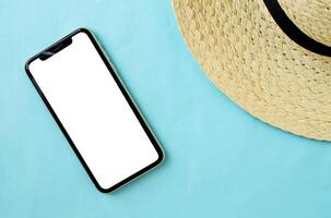 Mockup, smartphone and hat on a blue background. Summer vacation. photo