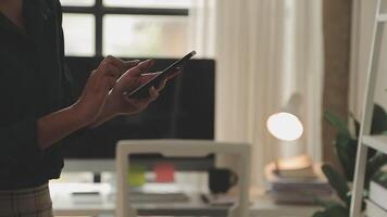 asiatische geschäftsfrau im formellen anzug im büro glücklich und fröhlich während der verwendung des smartphones und der arbeit video