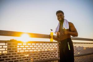 Portrait of young happy african-american man who is ready for exercising and jogging. photo