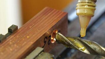 metalworking industry. close up hole drilling in copper bars for electrical connection on lathe boring machine with lubricant video