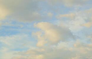 A blue cloudy sky with many small clouds blocking the sun photo