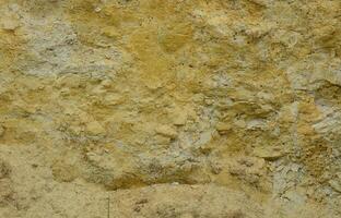 Texture of a wall of solid yellow and brown sand in a sandy quarry photo