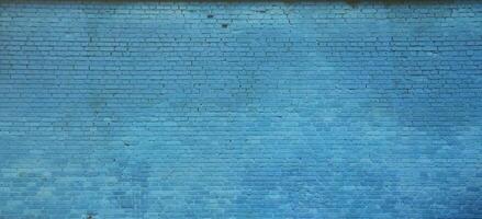 The texture of the brick wall of many rows of bricks painted in blue color photo