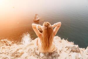 Woman travel sea. Happy tourist enjoy taking picture outdoors for memories. Woman traveler looks at the edge of the cliff on the sea bay of mountains, sharing travel adventure journey photo