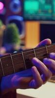 vertical vídeo profesional compositor de canciones jugando guitarra y utilizando caja de resonancia para mezcla y dominar pistas productor composición un canción con audio equipo a hogar grabación estudio, igualdad herramientas. cámara una. video