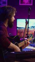 vertikal video musik producent blandning gitarr ljud spelade förbi honom på akustisk instrument, använder sig av elektronisk soundboard trösta och daw programvara. skicklig musiker utvecklande ny låtar, Hem studio. kamera a.