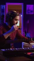 Vertikale Video erfahren Künstler Aufzeichnung seine Gitarre Lied zu mischen auf Morgengrauen Software, Arbeiten mit elektronisch Resonanzboden Ausrüstung. Audio- Ingenieur produzieren Tonspuren oder Klang Auswirkungen im seine Zuhause Studio. Kamera b.