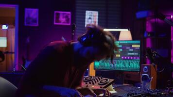 Energetic confident artist playing electronic piano in home studio, recording midi controller synthesizer notes to add audio effects. Cheerful sound engineer having fun with keyboard. Camera B. video