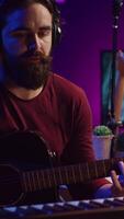 verticale vidéo musical compositeur enregistrement le sien guitare airs et ajouter piano clé des sons, création une magnifique chanson avec mélange console et choucas logiciel. du son ingénieur travail avec électronique outils. caméra b. video