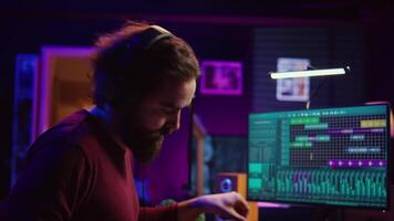 Skilled artist playing piano keyboard and recording sounds on daw software, capturing audio track instruments and vocals. Producer creating songs with mixing console in post production. Camera B. video