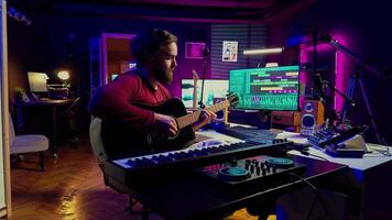 la musique producteur en jouant guitare à créer airs et mélanger leur après, ayant amusement avec musical instrument et amplificateur à le sien Accueil studio. talentueux artiste auteur compositeur composition une Nouveau piste. caméra un. video