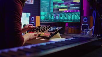 Sound engineer mixing and mastering sounds with electronic audio console, pressing controls and pre amp knobs. Music producer improving sound quality, synchronize soundtracks. Camera B. video