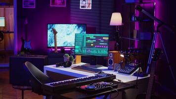 Empty home studio equipped with mixing console and soundboard, piano and other musical instruments to help with track recording. Mastering and mixing tunes on pc software, panel controls. Camera B. video