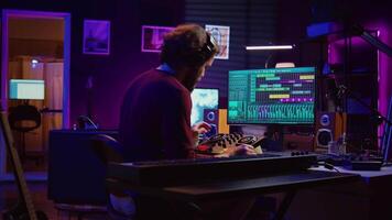 Musician playing piano keyboard and recording to mix and master audio, editing audio recordings to achieve desired sound quality. Artist producer operating on daw software. Camera B. video