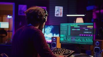 Mastering engineer registering piano keys recordings to edit in daw software on computer, operating his mixing equipment. Artist works on editing and manipulating recorded sounds and tunes. Camera B. video