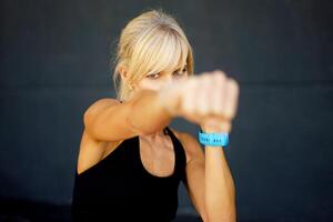 Strong young woman practicing boxing in gym with fitness gym photo