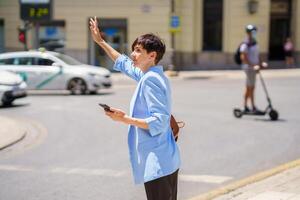 Confident woman making stop sign to taxi on city street photo