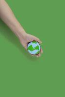 Earth Day concept. Cookie in shape of Earth in hand. photo