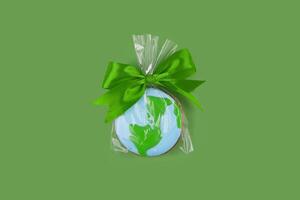 Earth Day concept. Cookie in shape of Earth on green backdrop. photo