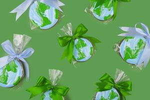 Earth Day concept. Cookie in shape of Earth on green backdrop. photo