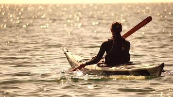 mulher mar caiaque. feliz sorridente mulher dentro caiaque em oceano, remar com de madeira remo. calma mar água e horizonte dentro fundo. ativo estilo de vida às mar. verão período de férias. video