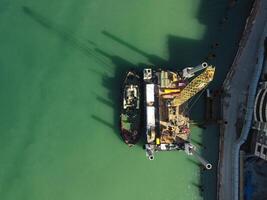 Floating crane dredging barges working on the construction of a marina. Aerial top view photo