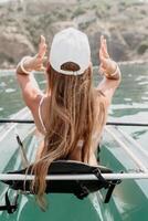 mujer en kayac espalda vista. contento joven mujer con largo pelo flotante en transparente kayac en el cristal claro mar. verano fiesta vacaciones y alegre hembra personas relajante teniendo divertido en el barco foto