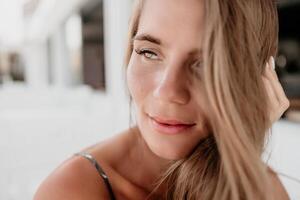 Happy woman portrait in cafe. Boho chic fashion style. Outdoor photo of young happy woman with long hair, sunny weather outdoors sitting in modern cafe.