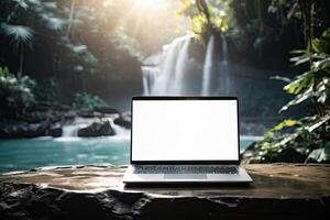 AI generated Laptop with blank white screen mock up on mountain lake in the rocks with waterfall in the tropical jungle. Remote work on vacation and travel, home office, internet, tours, trekking photo