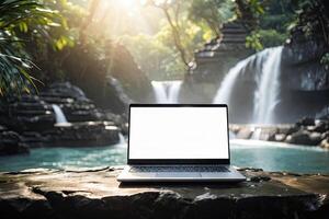 AI generated Laptop with blank white screen mock up on mountain lake in the rocks with waterfall in the tropical jungle. Remote work on vacation and travel, home office, internet, tours, trekking photo